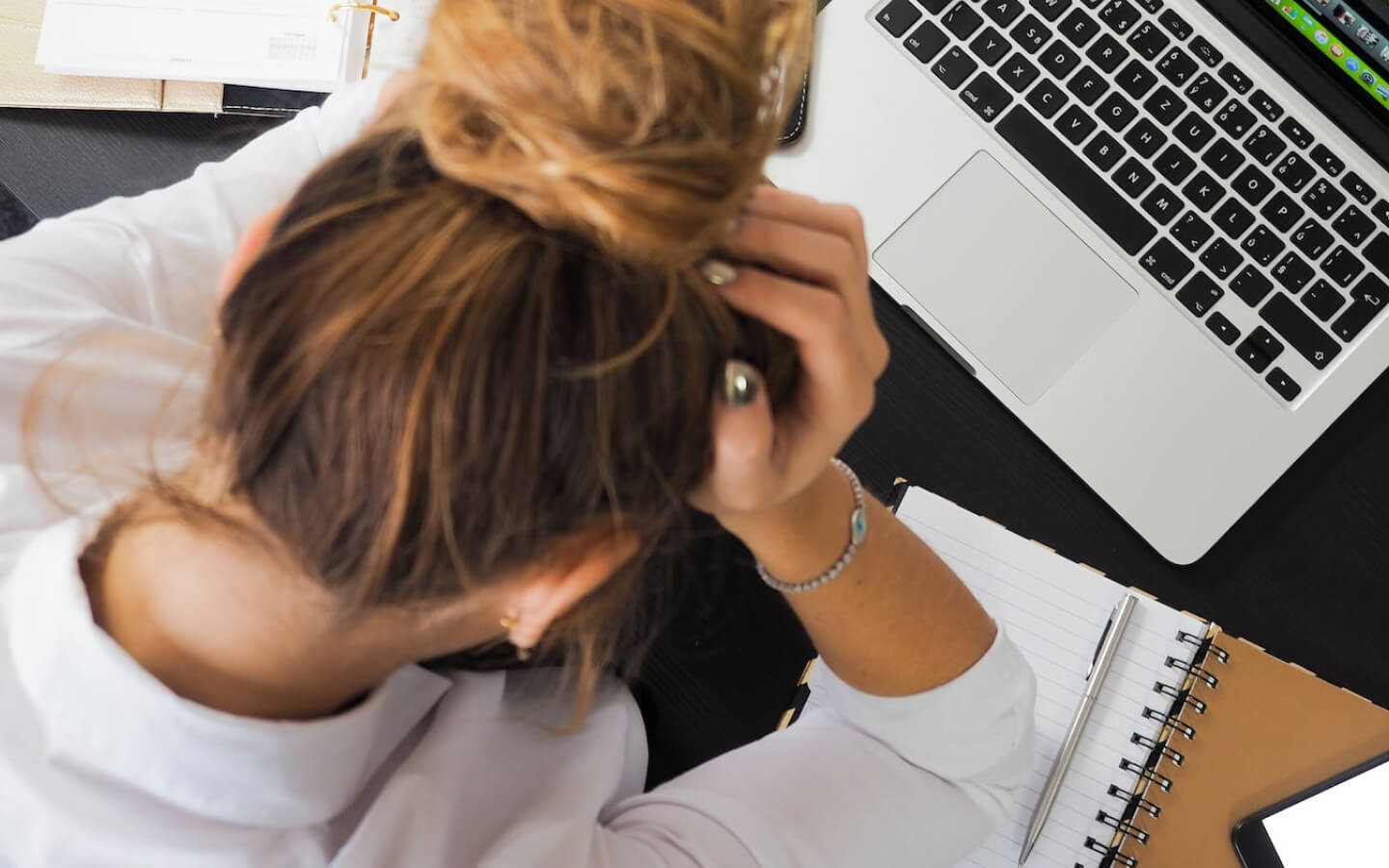 Holding head in frustration while sitting at computer