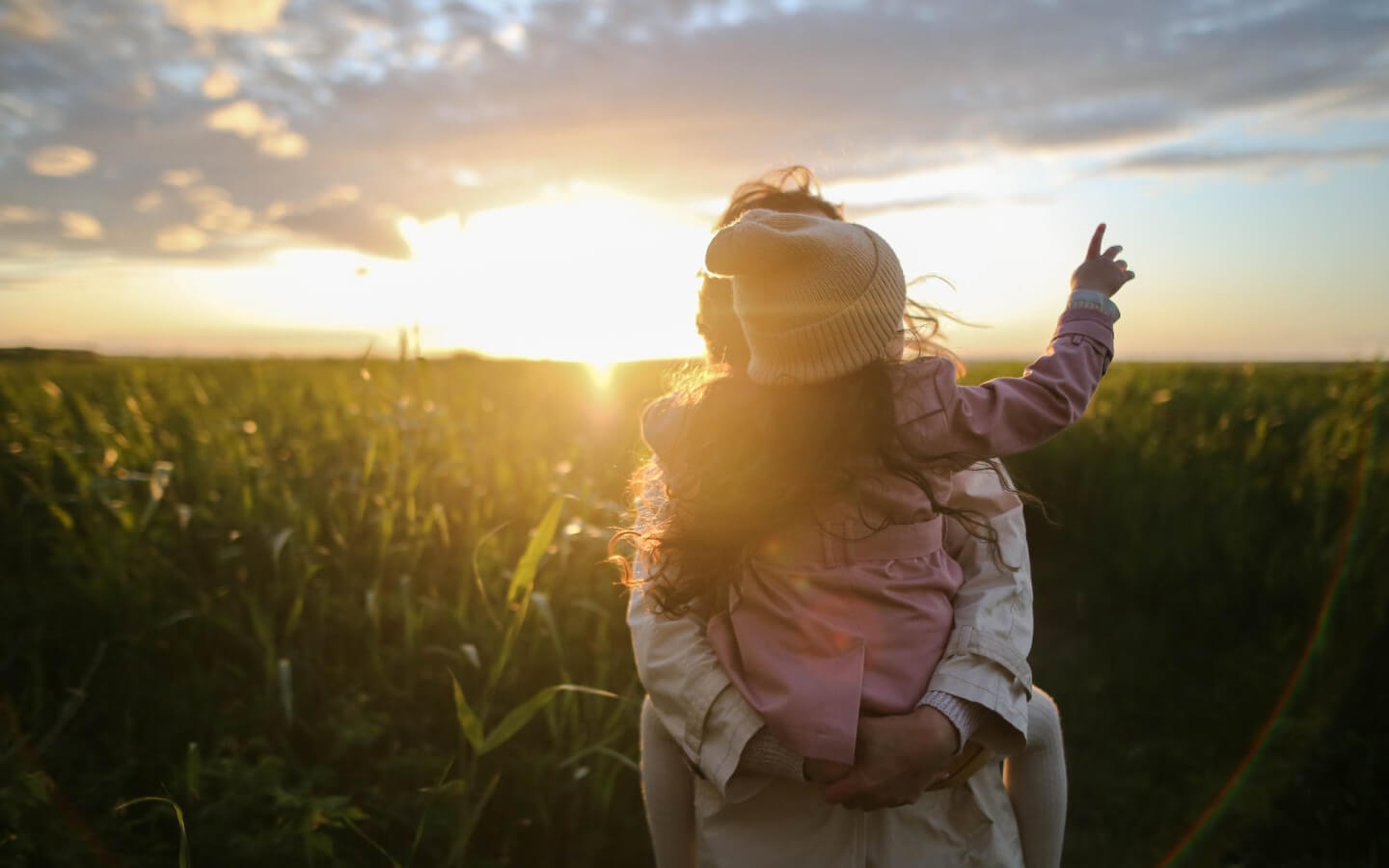 Mother holding her daughter outdoors