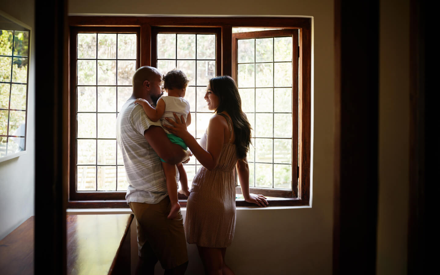 Young family holding child in home