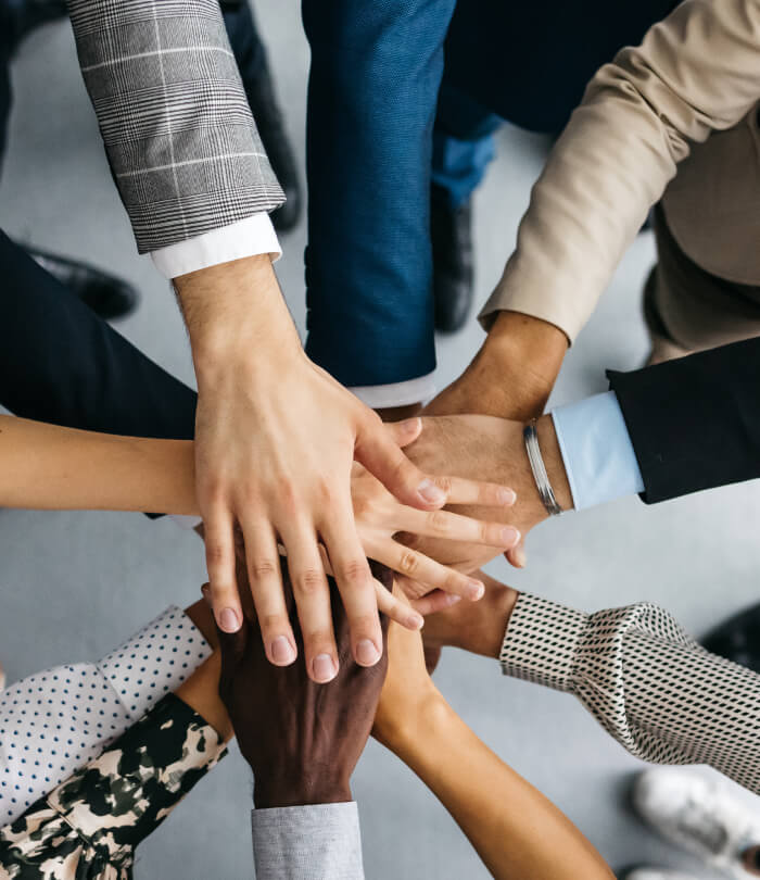 Close-up of co-workers stacking their hands together