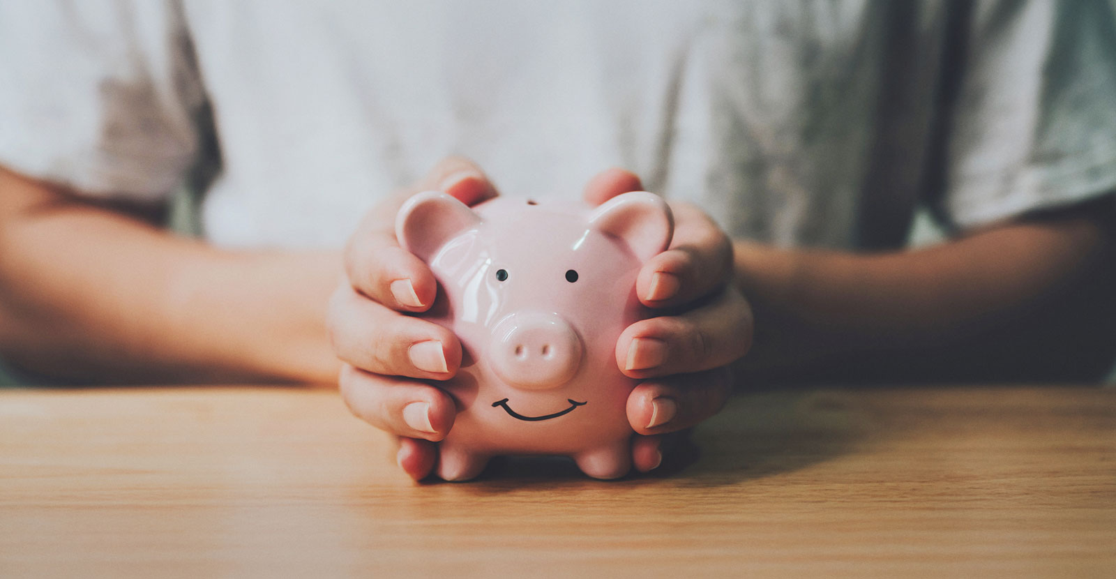 piggy bank with hands holding it